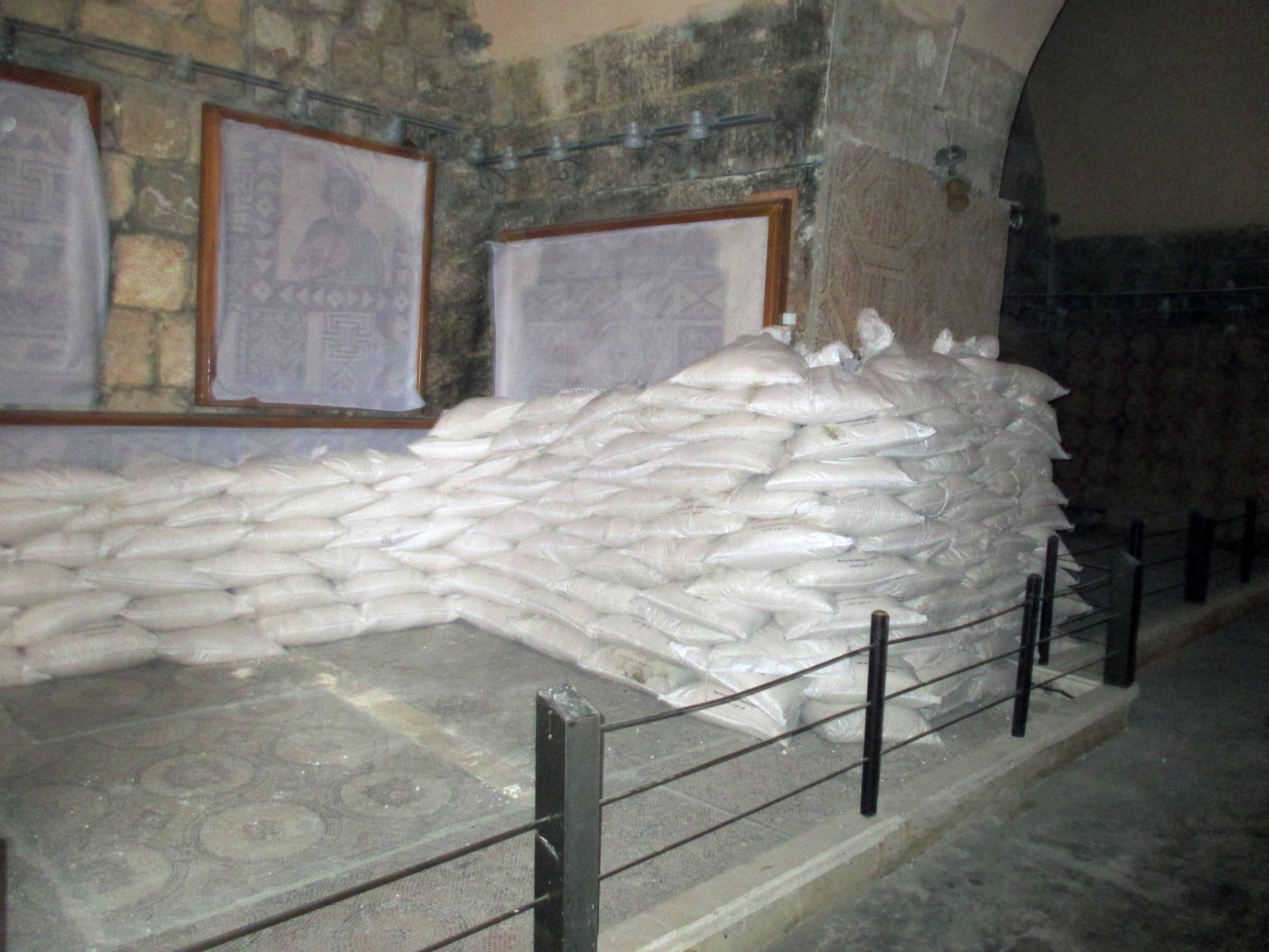Syrian volunteers covered mosaics in the Maโarra Museum in the Idlib province with a protective layer of glue and cloth, then several truckloads of sandbags were then laid out to protect the mosaics from damage caused by further attacks.