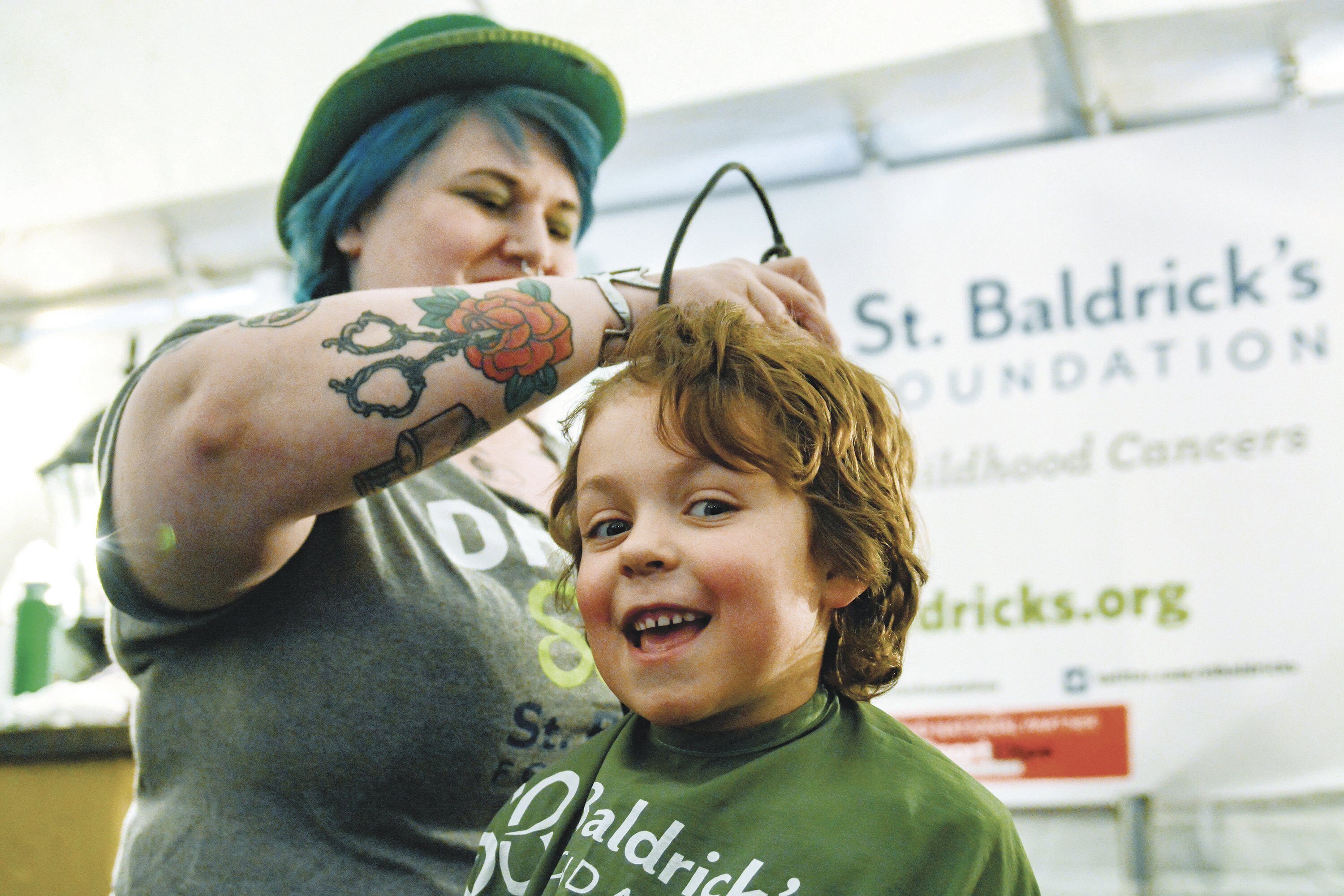 St. Baldrick’s Foundation pioneered events in which volunteers shave other volunteers bald to raise pledges. Here, Lynn Maldonado does the honors for Quinn Elbon-DeKay.