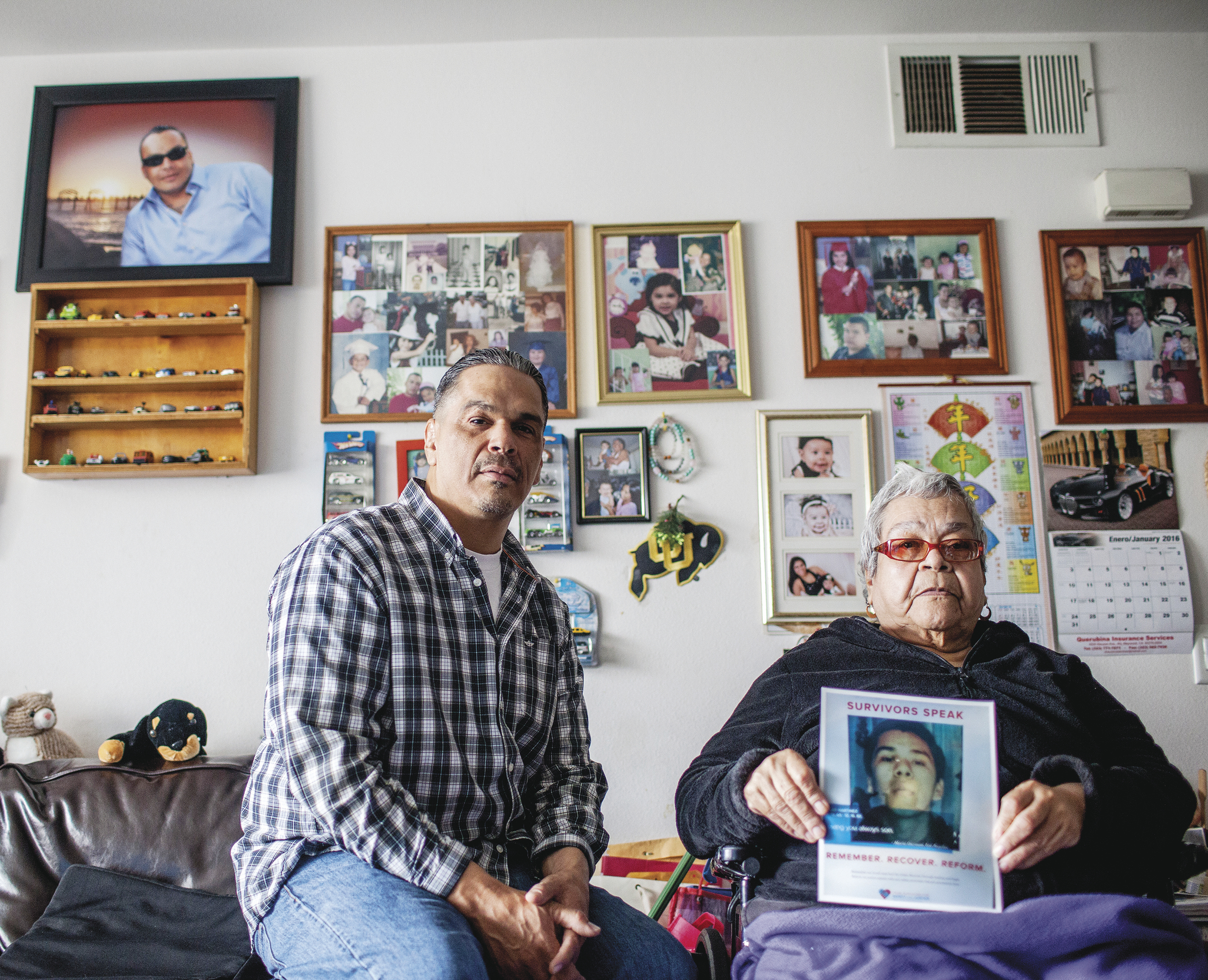 David Guizar visits his mother, Maria Guzman, who holds a picture of her slain son Oscar. On the wall behind them is a picture of another of Ms. Guzman’s sons, Gilbert, who was also murdered.