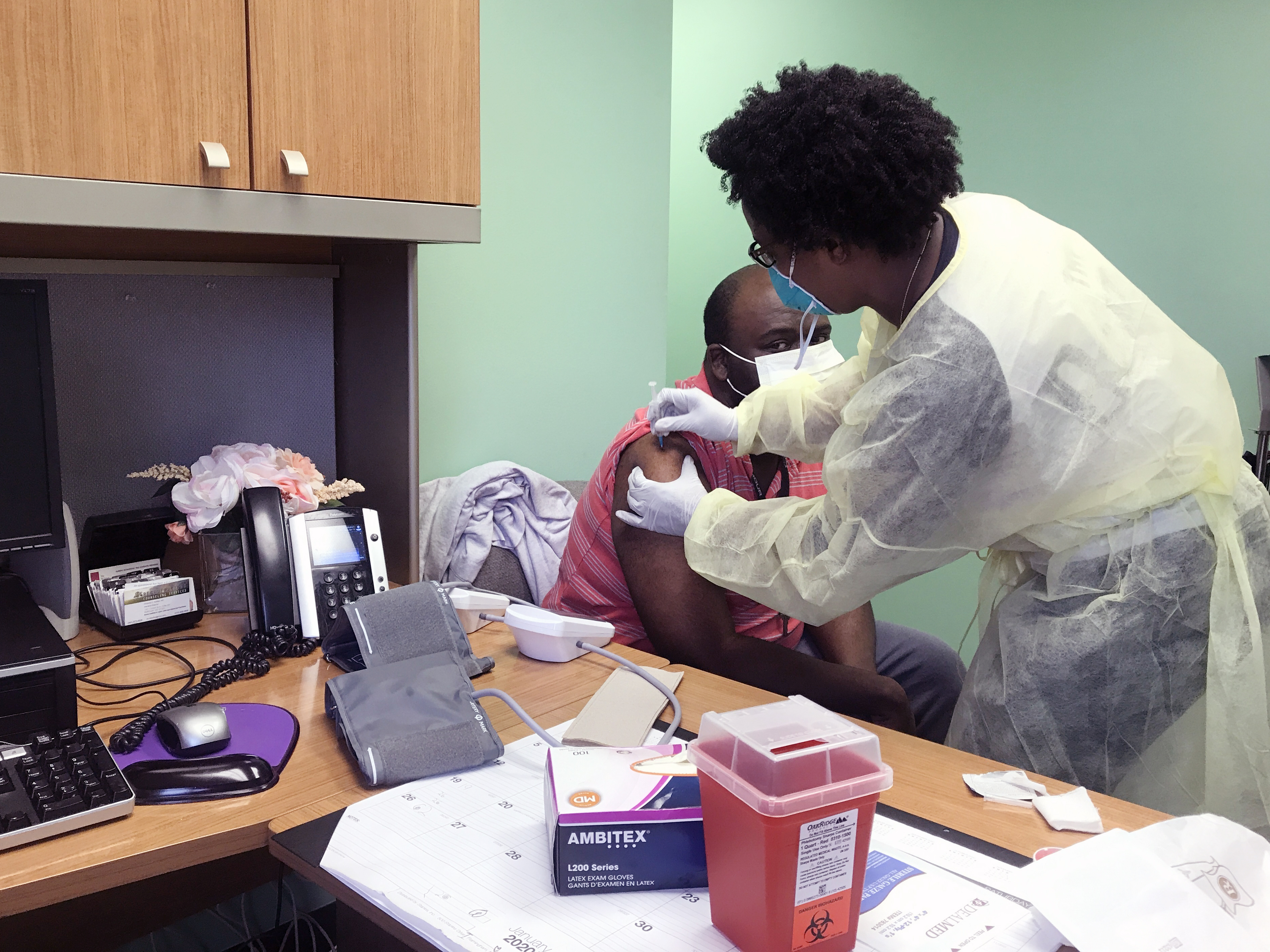 Photo of a nurse giving a patient a shot at Volunteers of America clinic