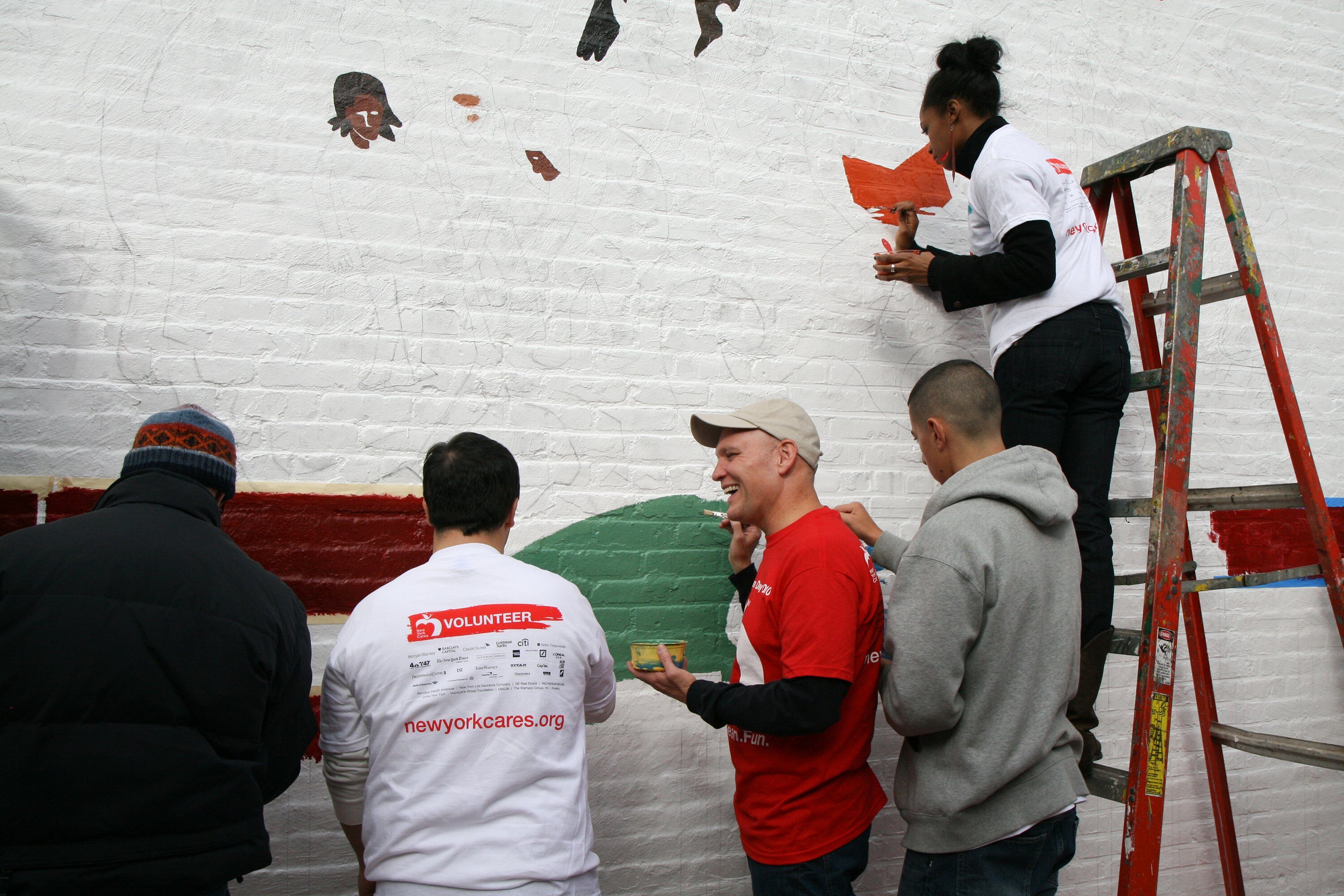 Volunteers paint a diversity-themed mural at PS 171 in New York during a day of service.