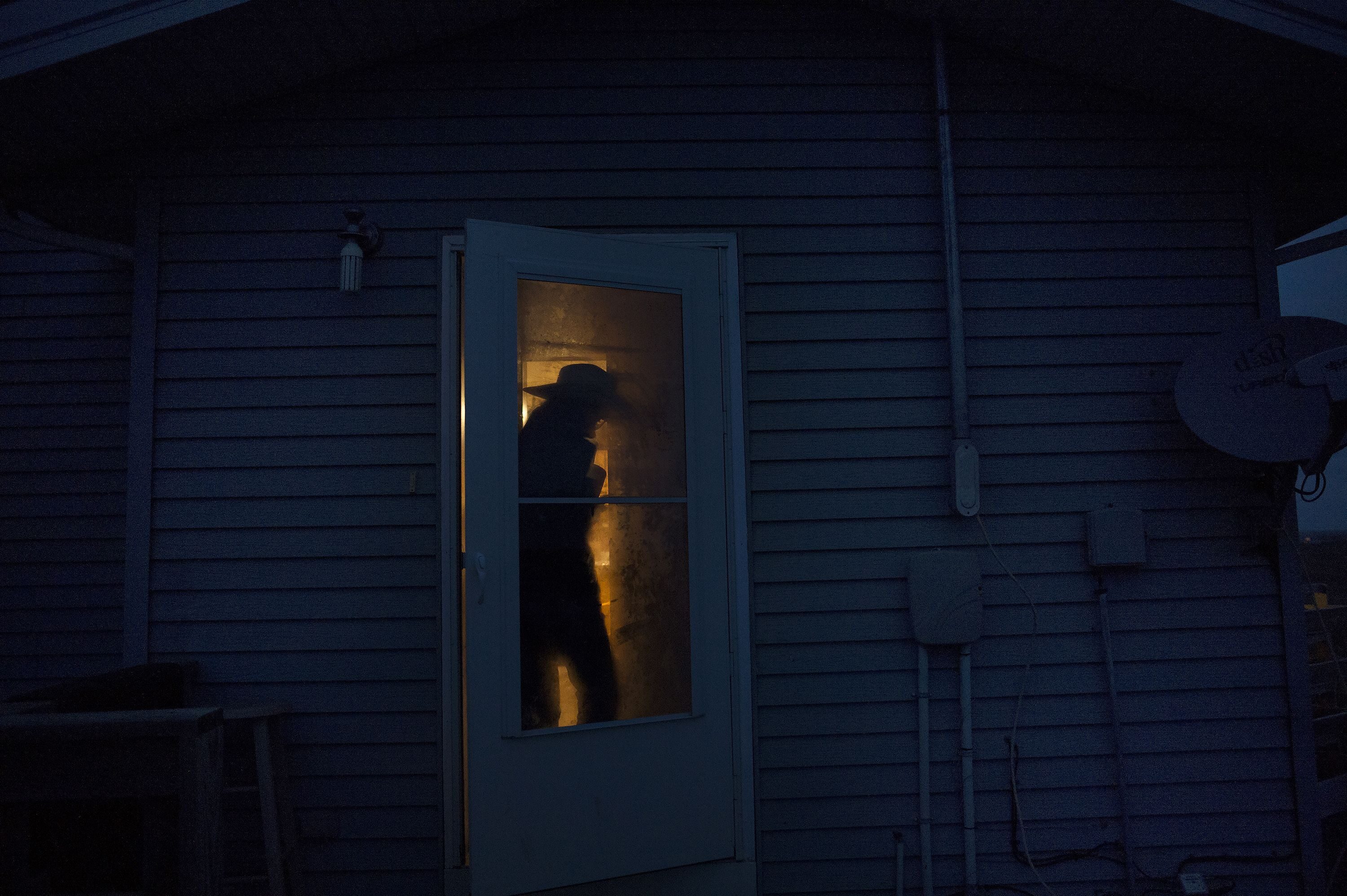 A rancher enters their home on a family ranch in South Dakota.