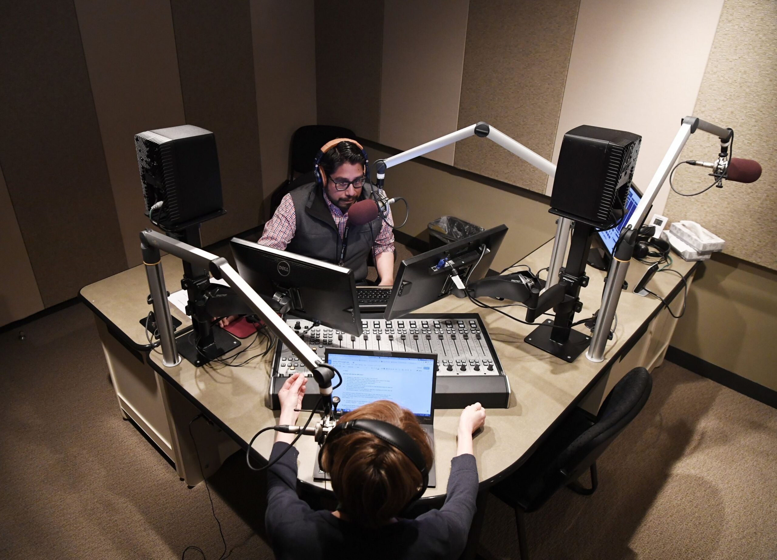 Colorado Public Radio producer Nathan Heffel, top, and energy and environment reporter Grace Hood do a run-though for their Colorado Matters program at CPR studios March 17, 2017 in Centennial, Colorado.