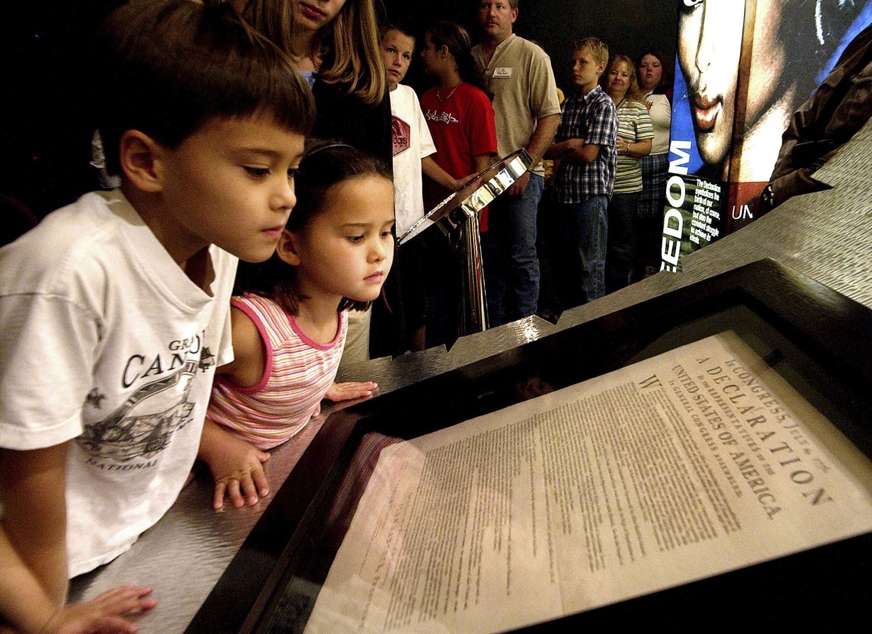 Children look at an original printed version of the Declaration of Independence at the Capitol in Phoenix.