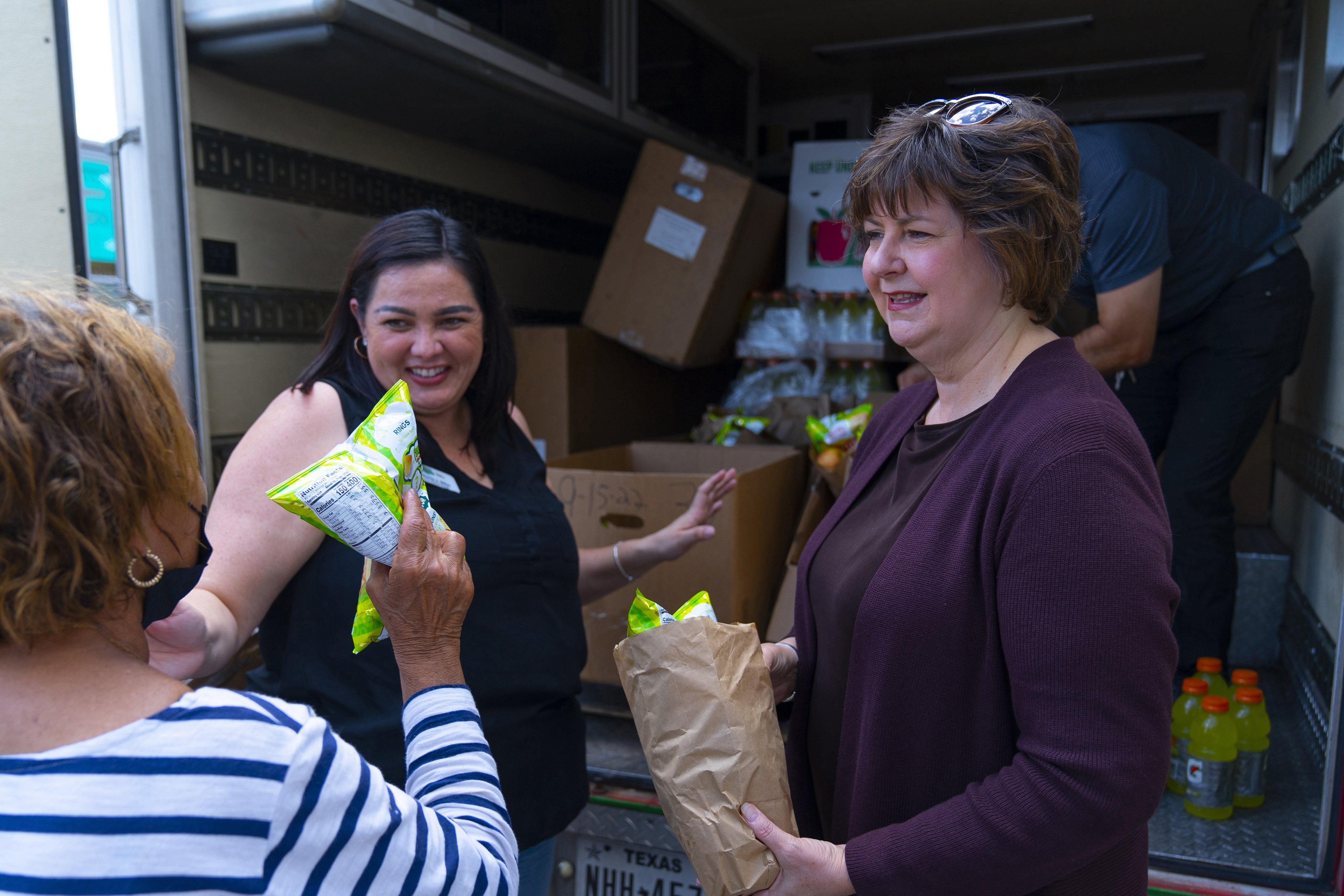 CEO Susan Goodell, right, and Gloria Siller, partner agency relations manager, hand out food and supplies to migrants dropped off in downtown El Paso. (Lonnie Valencia, El Pasoans Fighting Hunger Food Bank)
