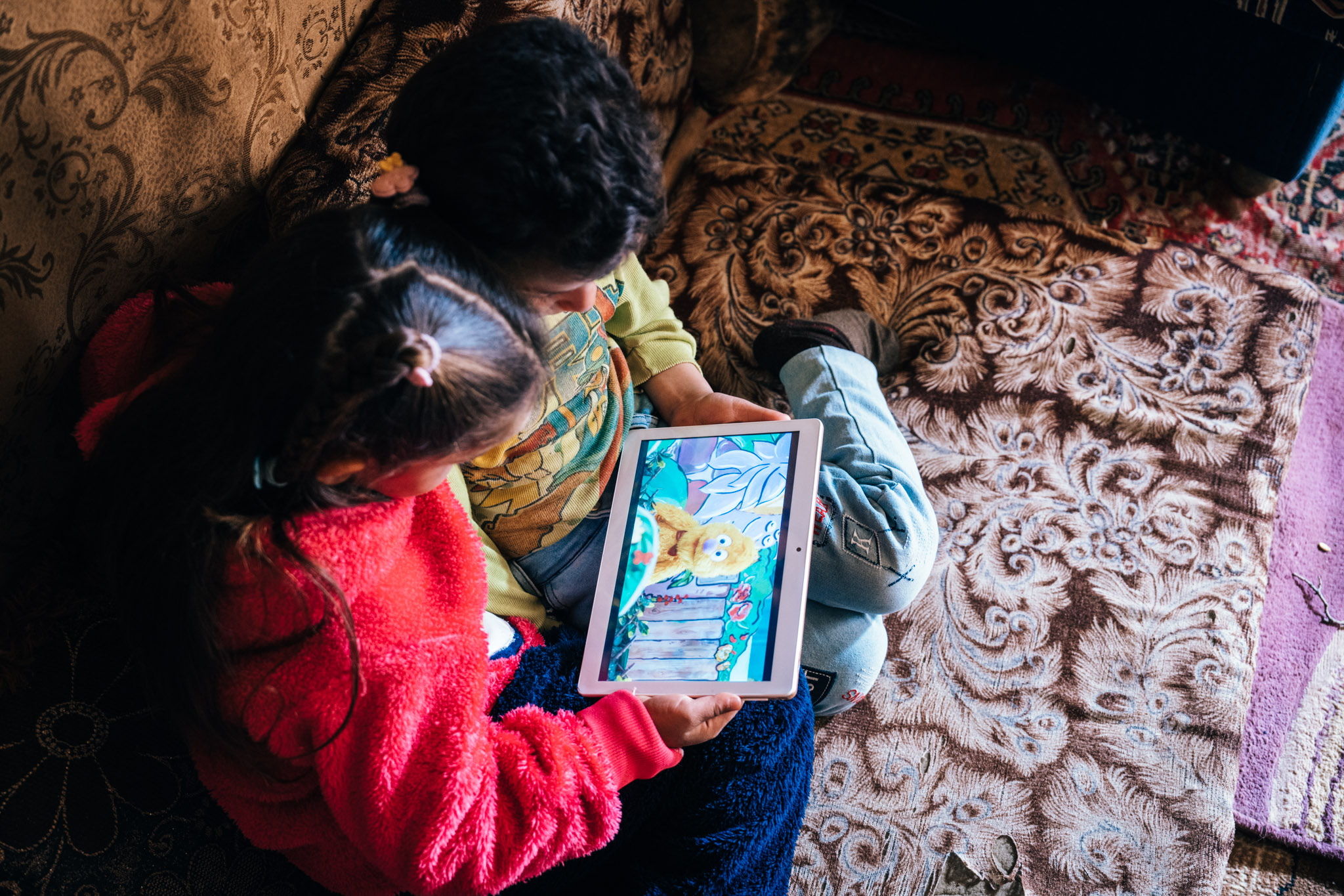 Two children watch the Ahlan Simsim TV show in Saida, Lebanon.