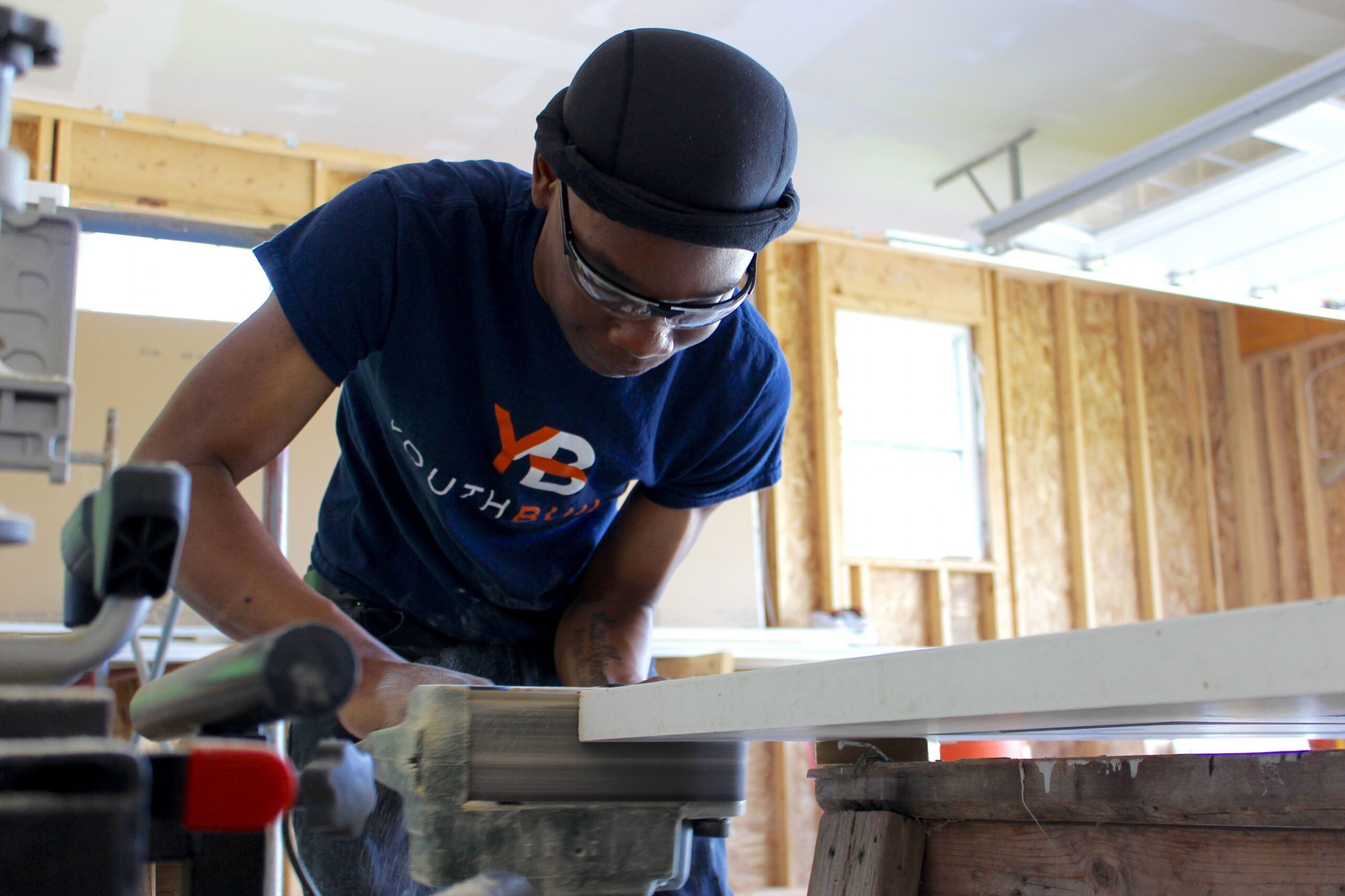 Kevontay Deans sands a door that will be installed at a new-construction, affordable home in Sun Prairie, Wisconsin.
