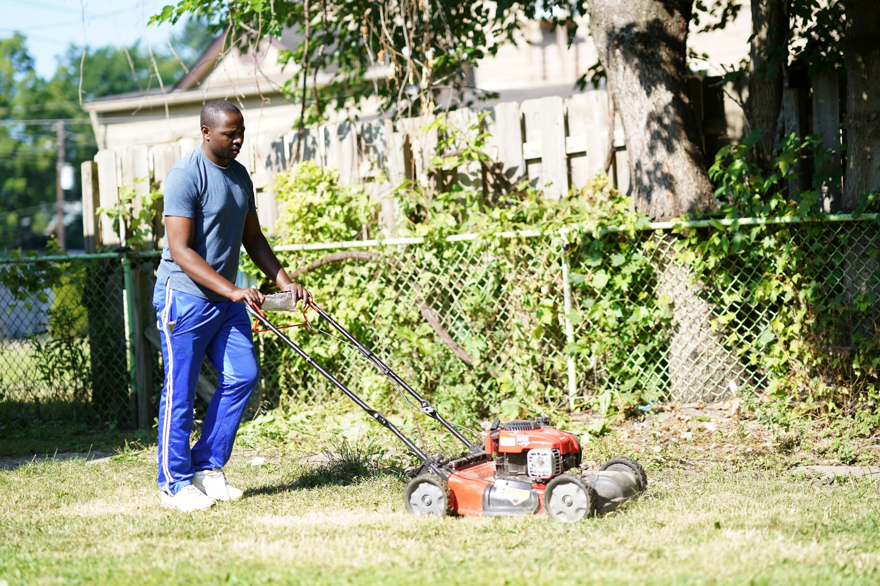 Makizimana Muvunye, owner of Asante Landscaping, cuts a lawn in Cleveland.