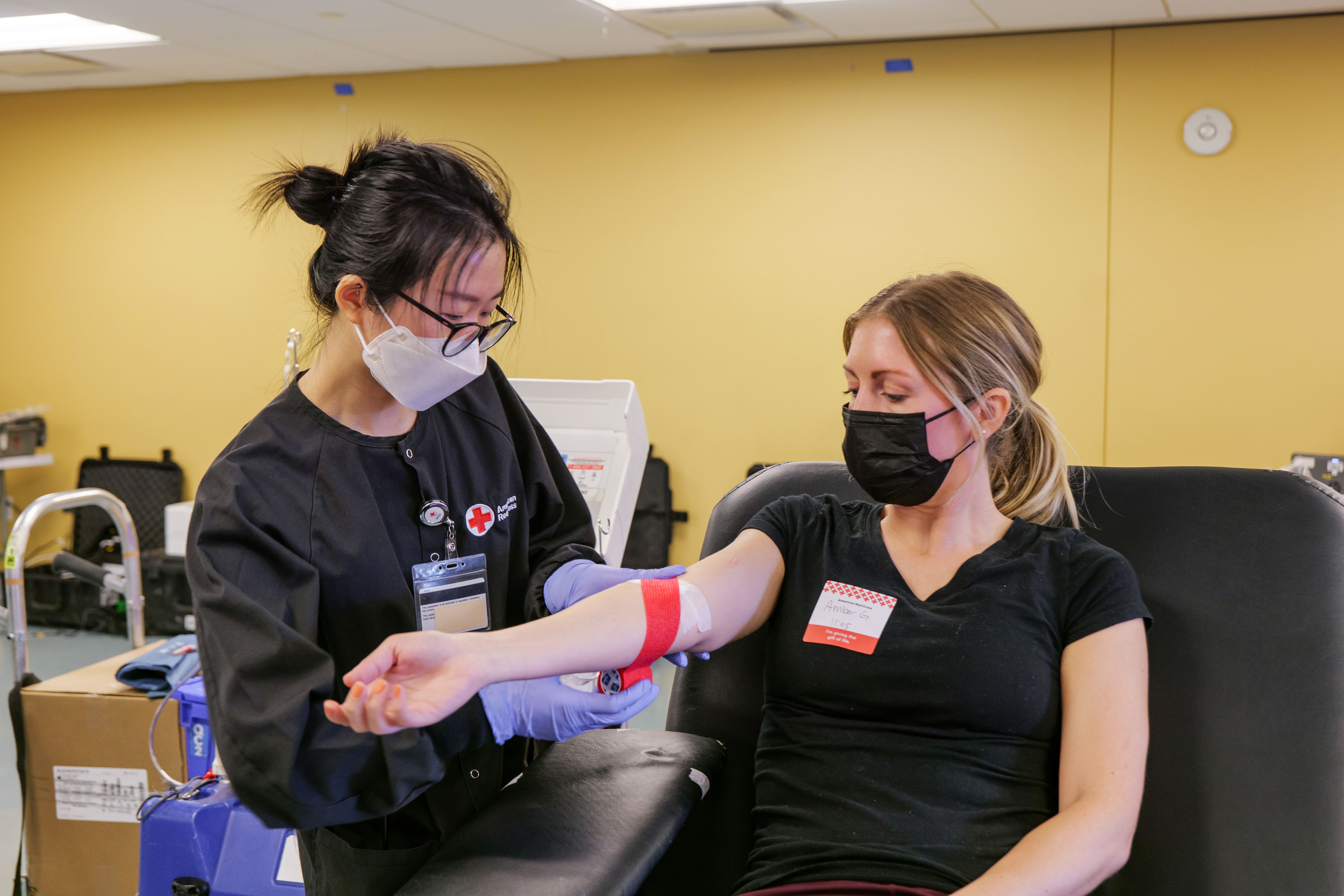 A person gives blood during a blood drive for the American Red Cross.