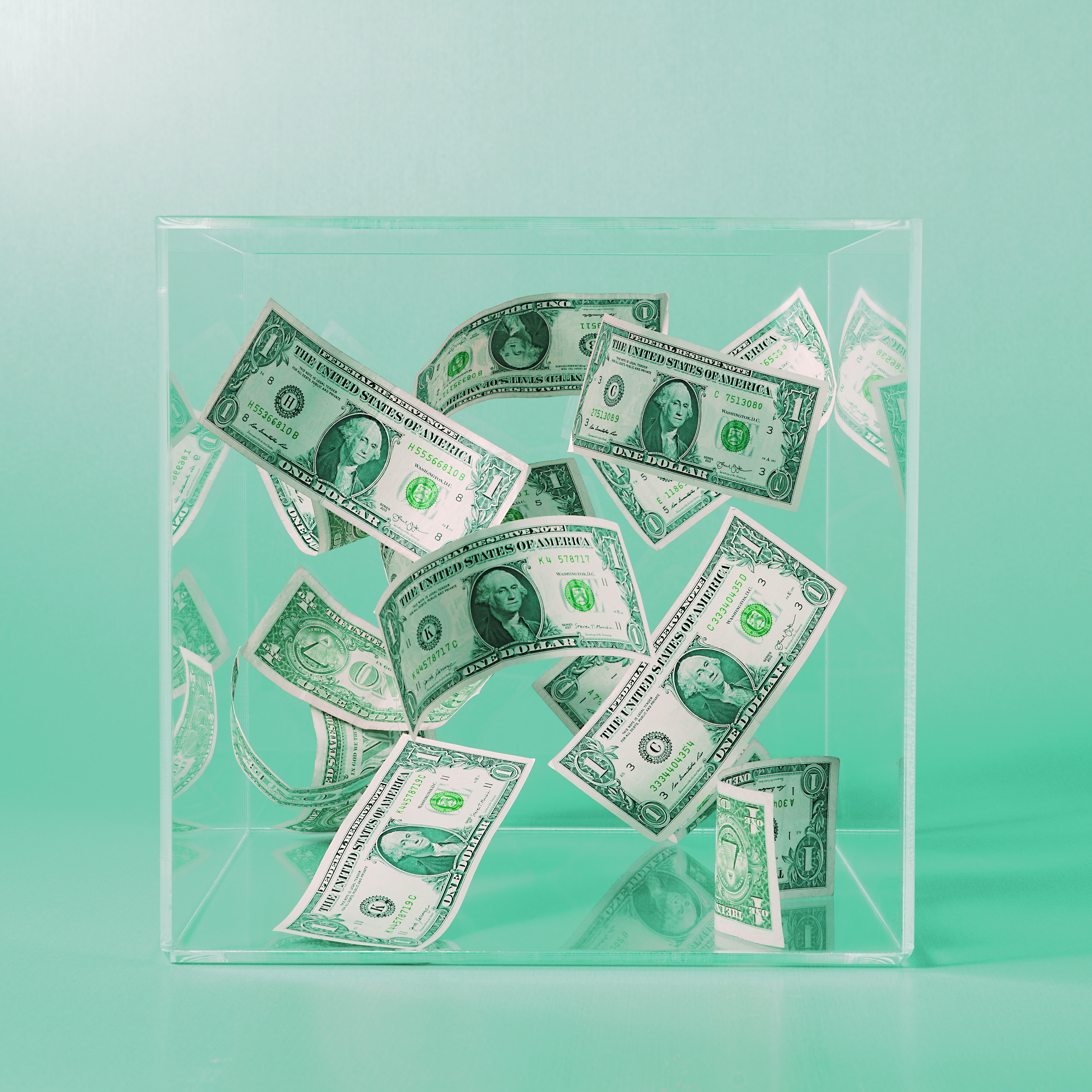 14 US 1 Dollar bills floating in a clear box on studio background, tinted green