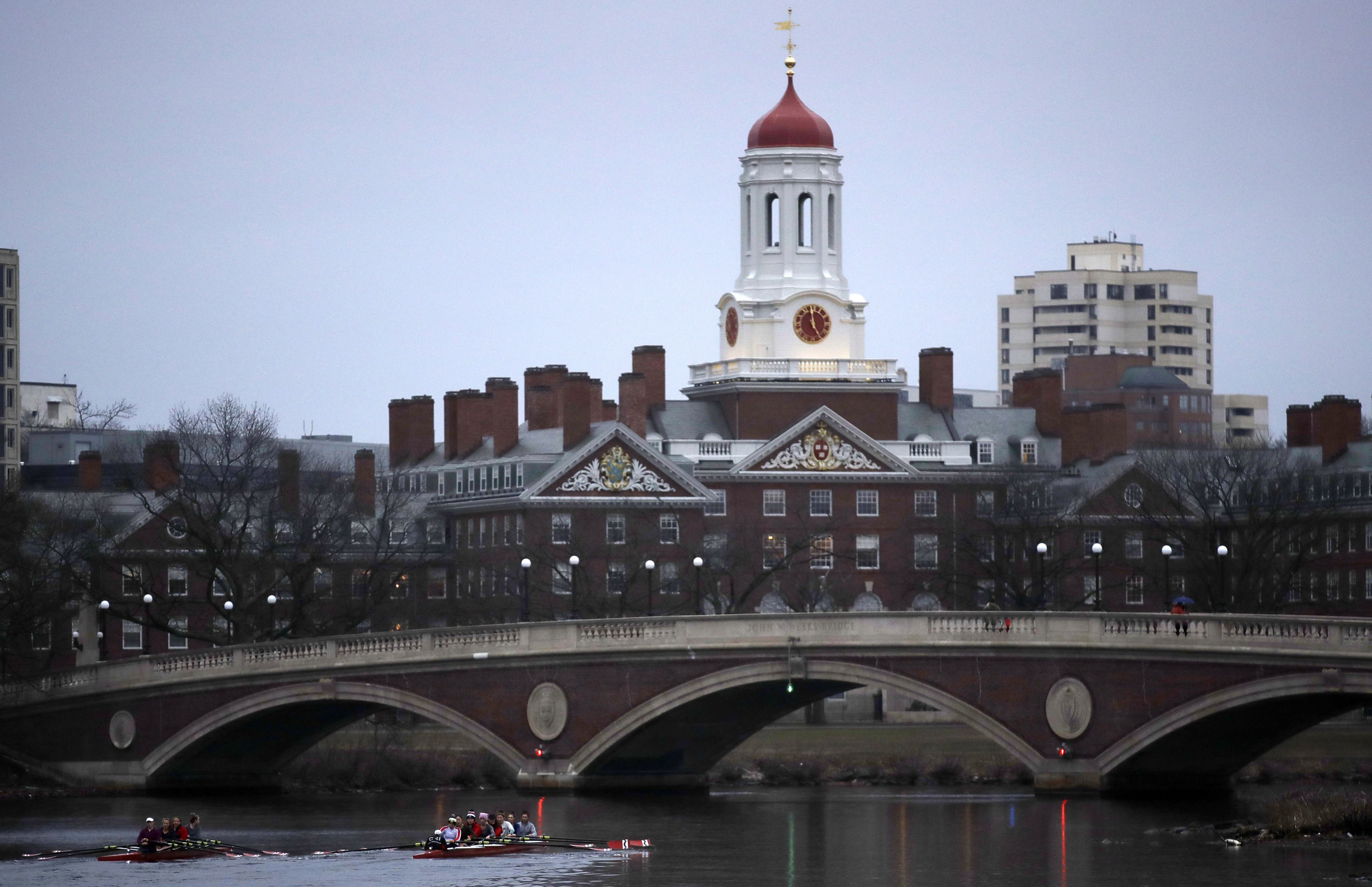 The Dunster House, one of the dormitories for Harvard University undergraduates, is seen in the background as rowers pass by on the Charles River in Cambridge, Mass.