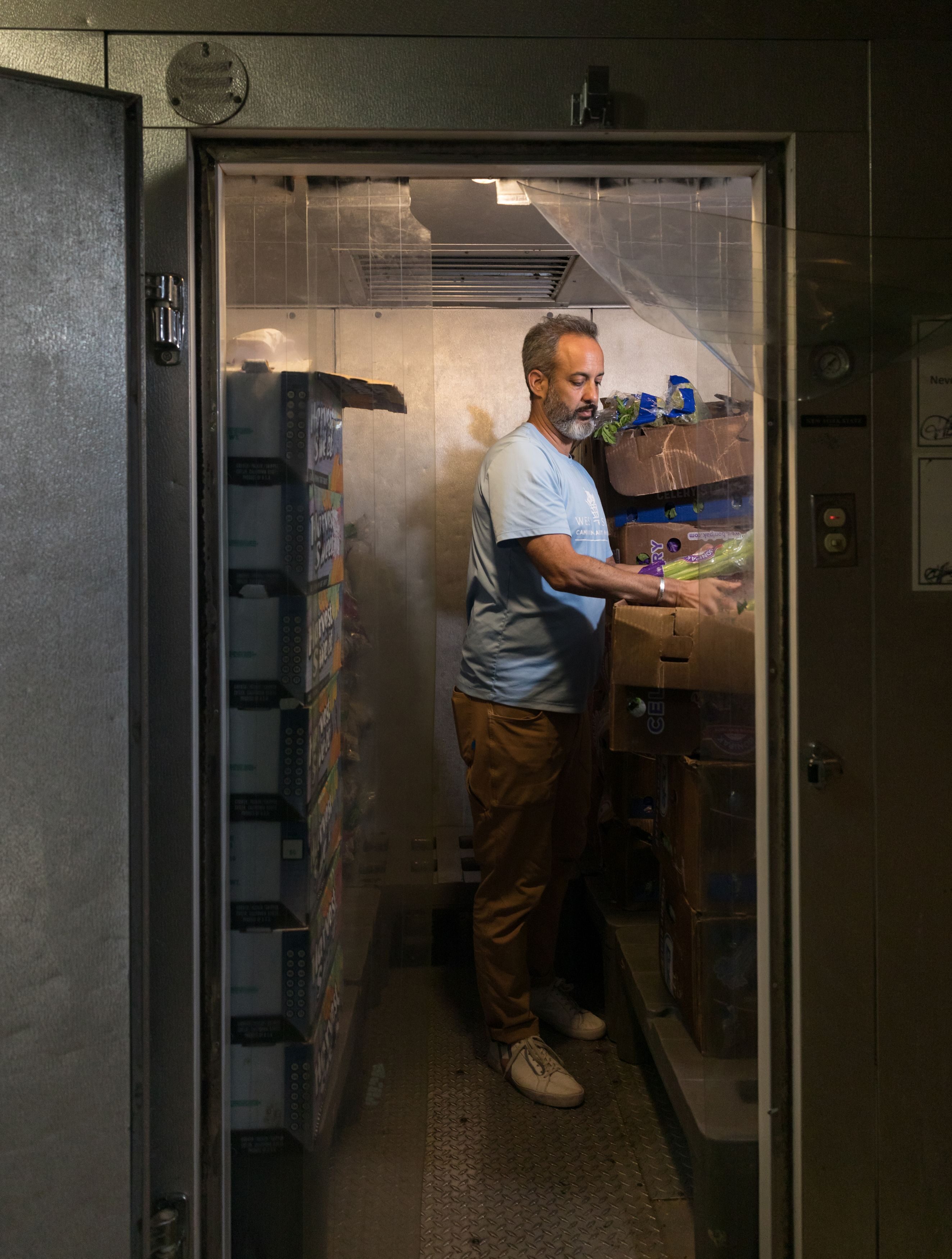 Greg Silverman, chief executive officer of the West Side Campaign Against Hunger, packs groceries for distribution at a food pantry.