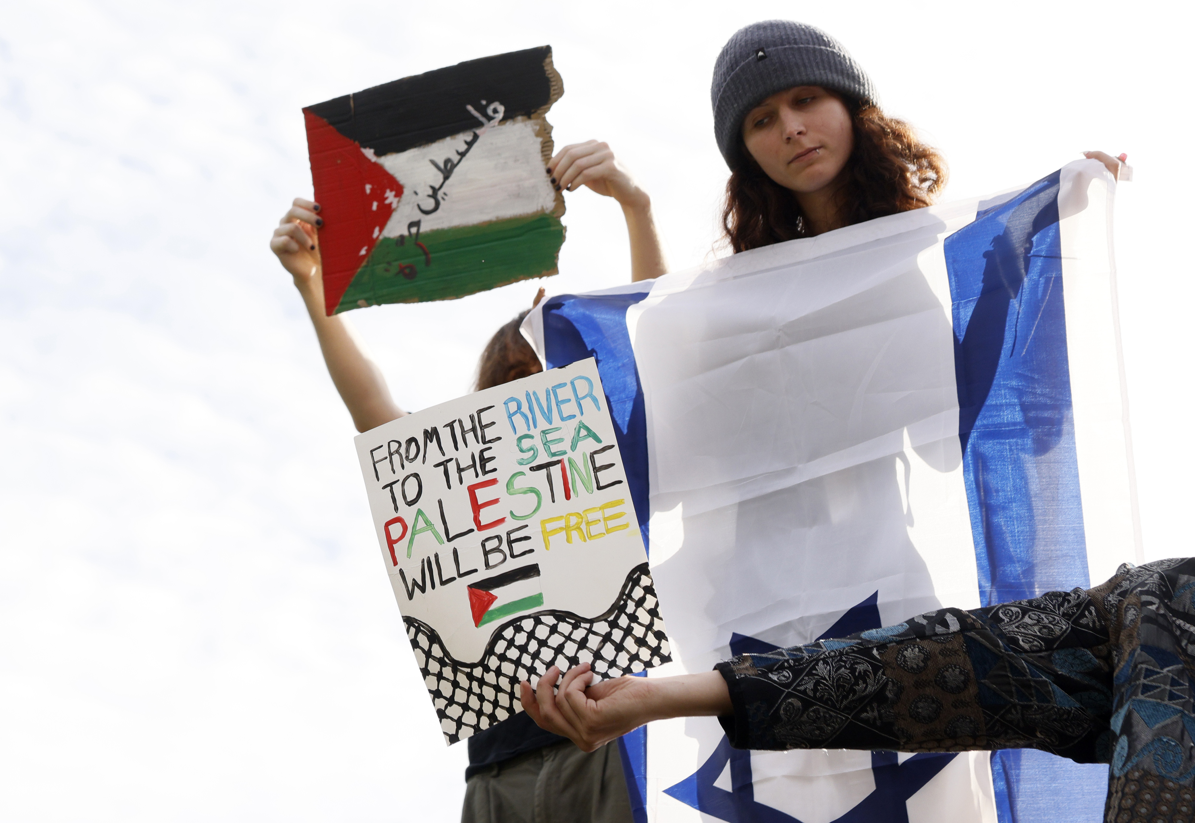 Pro-Palestinian protesters hold out signs to block a Pro-Israeli protester on the campus of University of Massachusetts Amherst.