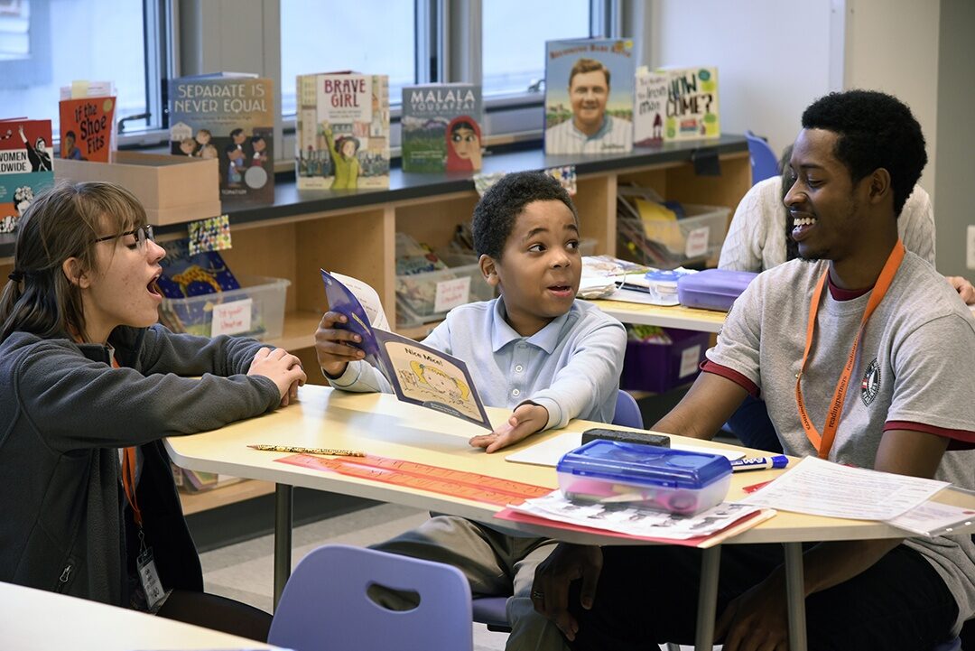 Cady Zuvich (left) checks in as Eean Thomas (right), like her a member of the AmeriCorps team at the Baltimore chapter of literacy nonprofit Reading Partners, conducts a tutoring session.