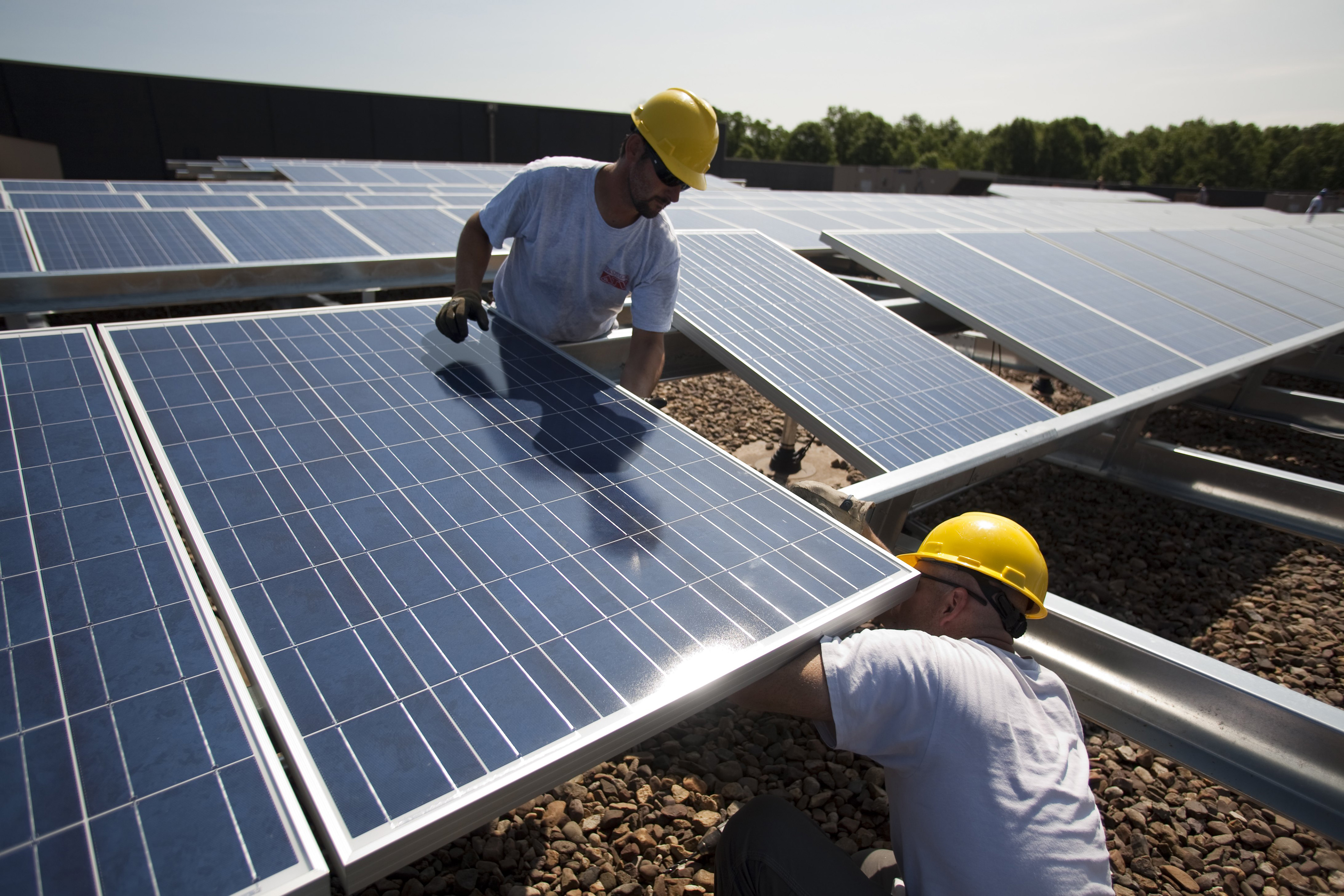 Contractors install 1248 photo voltaic modules on top of a Kohl's Department Store roof June 2, 2010 in Hamilton Township, New Jersey. The project is part of a SunEdison Corporation contract with Kohl's, a nation-wide department store. (Robert Nickelsberg, Getty Images)