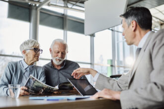 A man sits across from an older couple discussing planned gifts