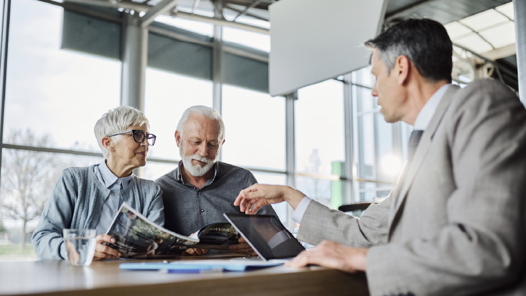 A man sits across from an older couple discussing planned gifts