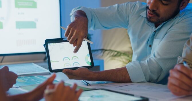 A businessperson pointing to a data graphic on a computer screen